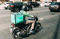 Entregador da Careem entregando comida em uma scooter.
