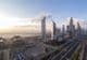 Sheikh Zayed Road com linha do horizonte de Dubai ao amanhecer.