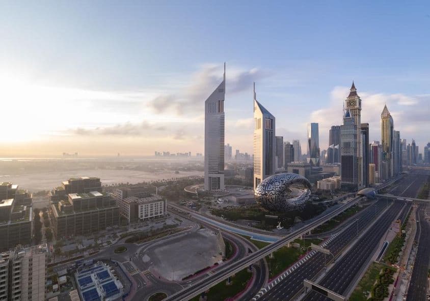 Sheikh Zayed Road com linha do horizonte de Dubai ao amanhecer.