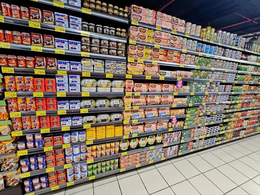 prateleira de supermercado com produtos enlatados coloridos, atum e vegetais