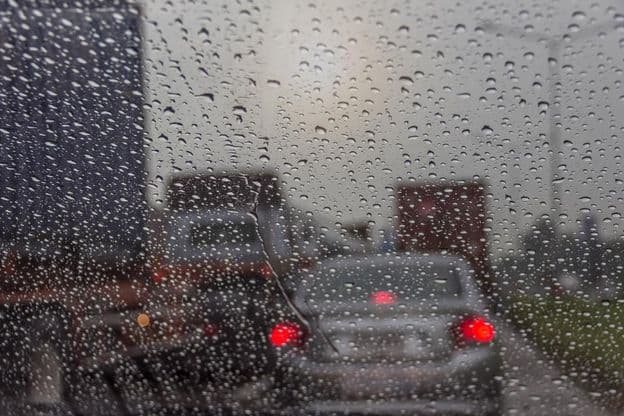 Chuva vista através de uma janela de carro.