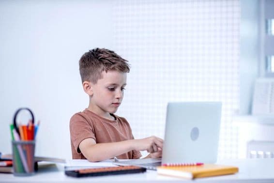Criança escolar conversando com professor via videoconferência no computador