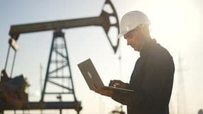 Um técnico verifica o funcionamento de uma bomba de petróleo no deserto.