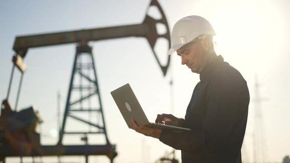 Um técnico verifica o funcionamento de uma bomba de petróleo no deserto.