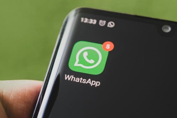 O ícone do WhatsApp na tela preta de um smartphone.
