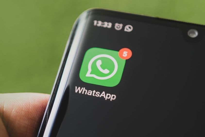 O ícone do WhatsApp na tela preta de um smartphone.
