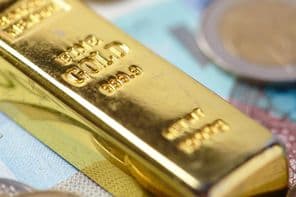barras de ouro em cima de notas de banco