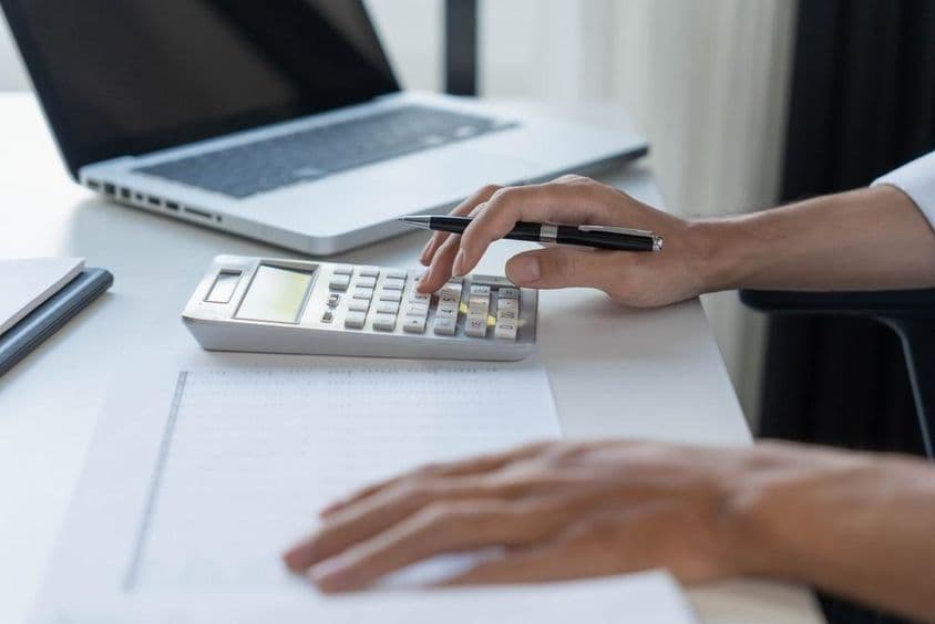 Contador calculando em uma calculadora.