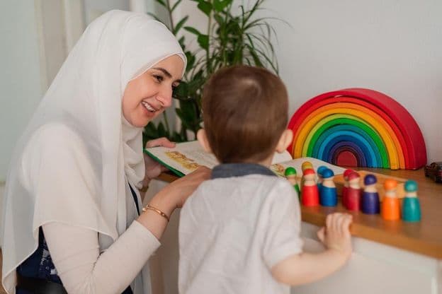 Um professor muçulmano e uma criança em idade pré-escolar brincando com brinquedos coloridos