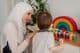 Um professor muçulmano e uma criança em idade pré-escolar brincando com brinquedos coloridos