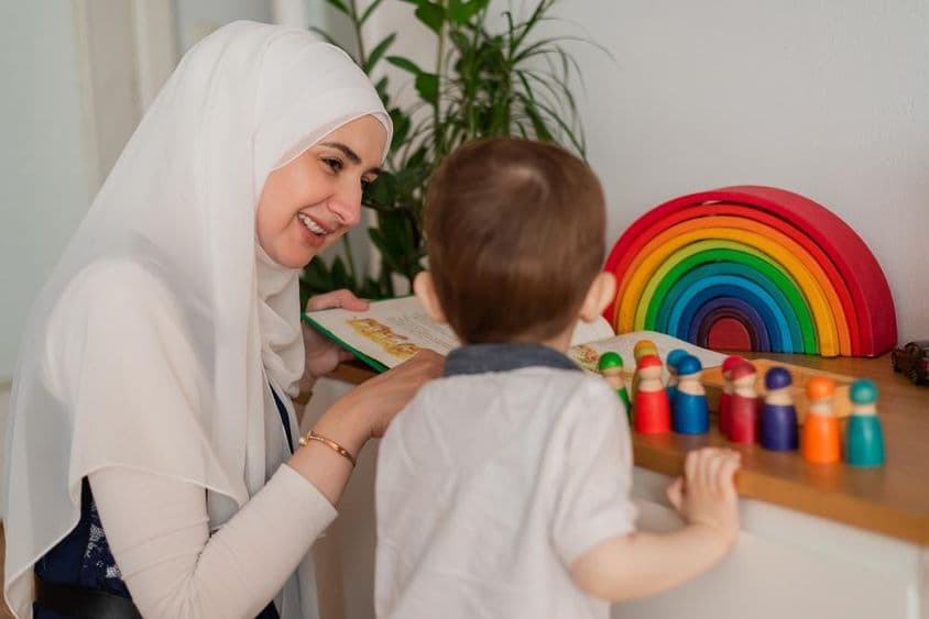 Um professor muçulmano e uma criança em idade pré-escolar brincando com brinquedos coloridos