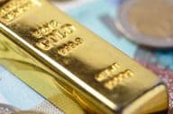 Barras de ouro sobre notas de banco