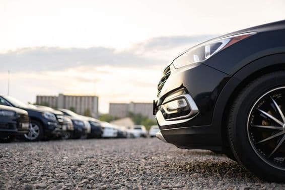 Carros estacionados em um estacionamento de cascalho