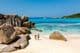 Dois viajantes caminhando nas areias brancas macias da Praia Anse Cocos em Seychelles.