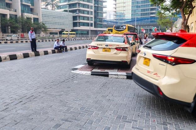 Um grupo de motoristas de táxi aguardando passageiros em frente a um hotel em Dubai.
