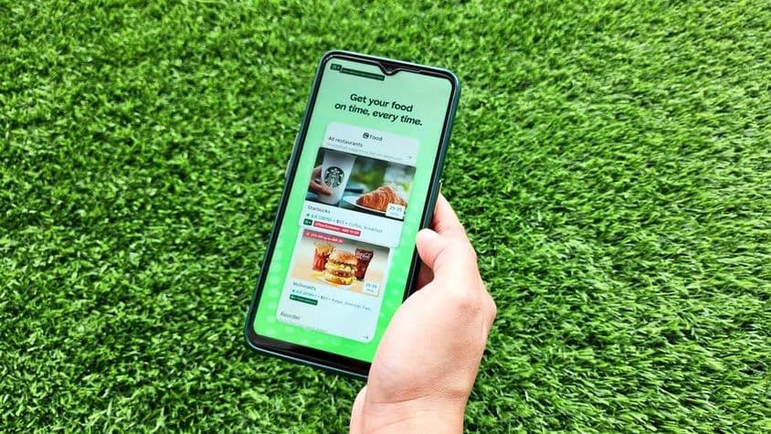 Uma mulher segurando um telefone celular enquanto abre o aplicativo Careem.