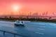 Rodovia e skyline de Dubai ao pôr do sol.