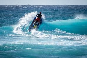 Jetski atinge a água acima de uma onda quebrando