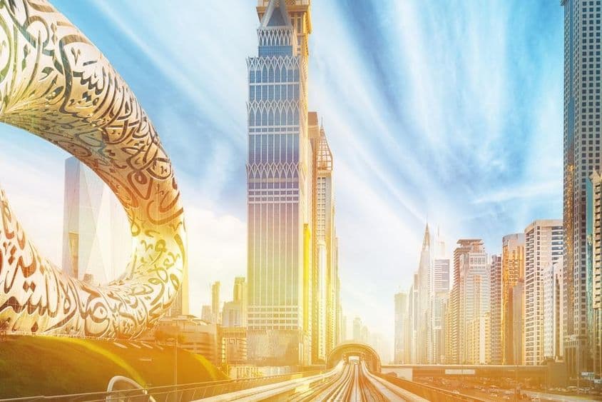 Linha de metrô entre arranha-céus de vidro em Dubai.